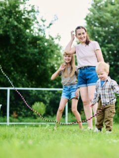family jumping rope in backyard