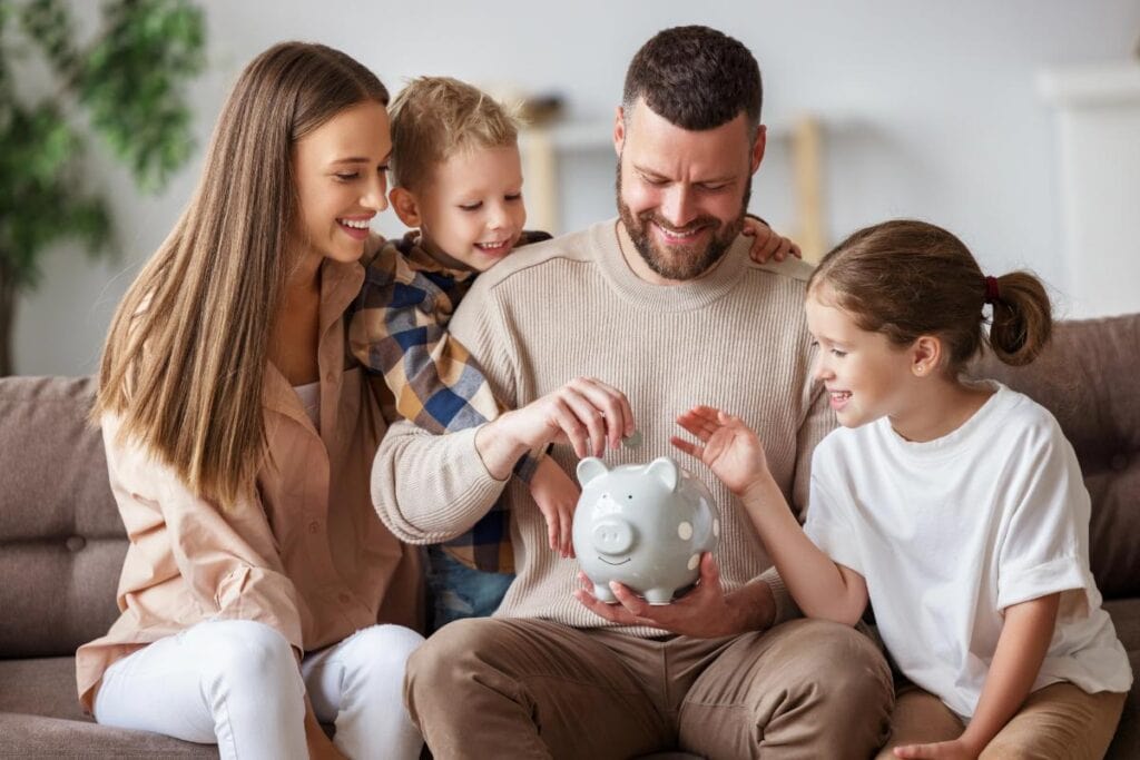 family sitting on couch adding coins to piggy bank