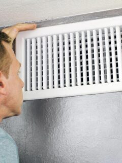 man looking at hvac vent