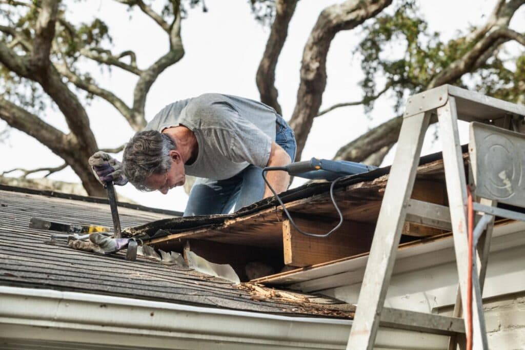 man looking at damaged roof