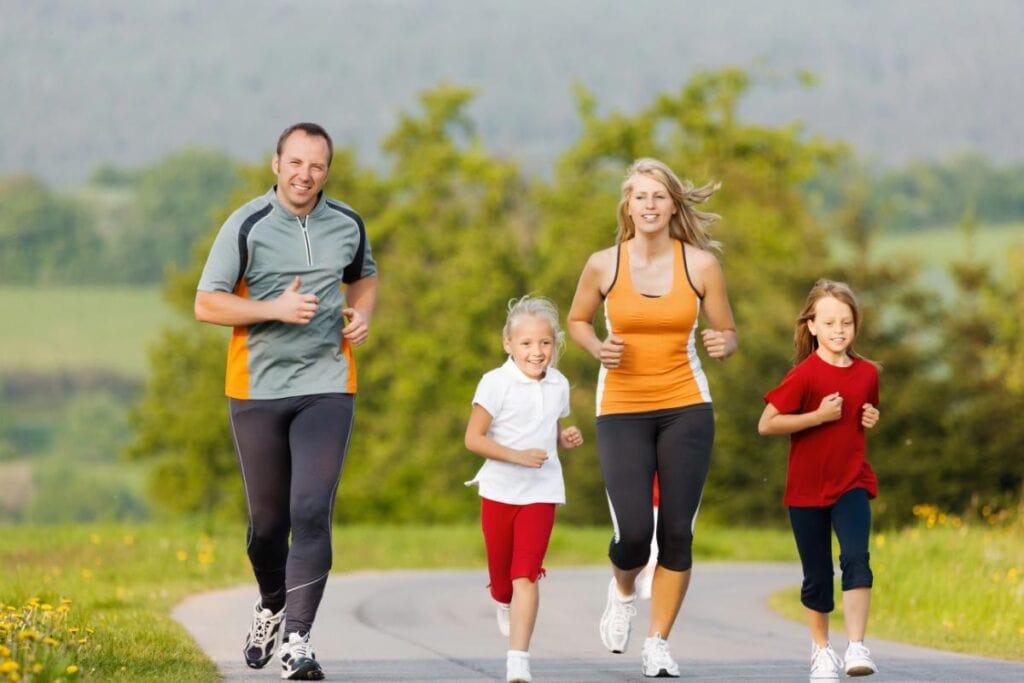 family running together - parents and daughters