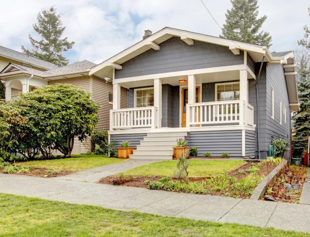 Small gray bungalow with a covered front porch and lawn
