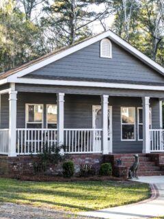 Compact gray cottage with white trim and a front porch
