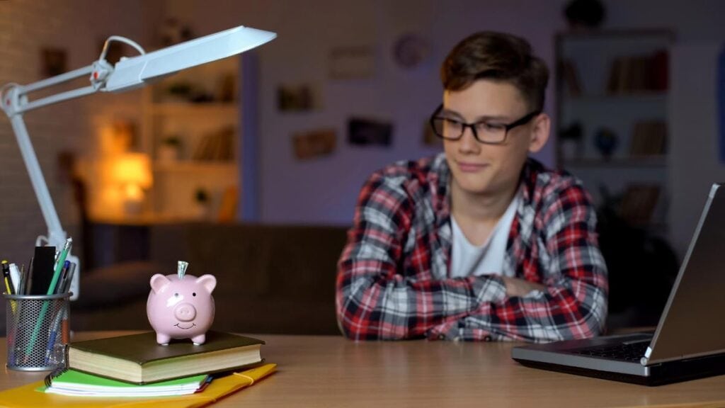 studious college guy with piggy bank