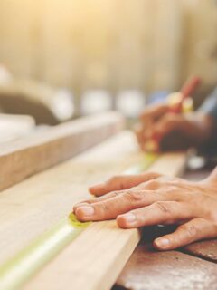 woman measuring a board before cutting