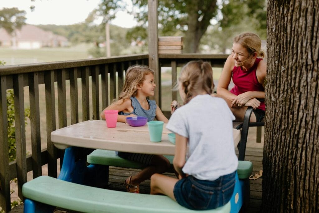kids and mom sitting outside on porch