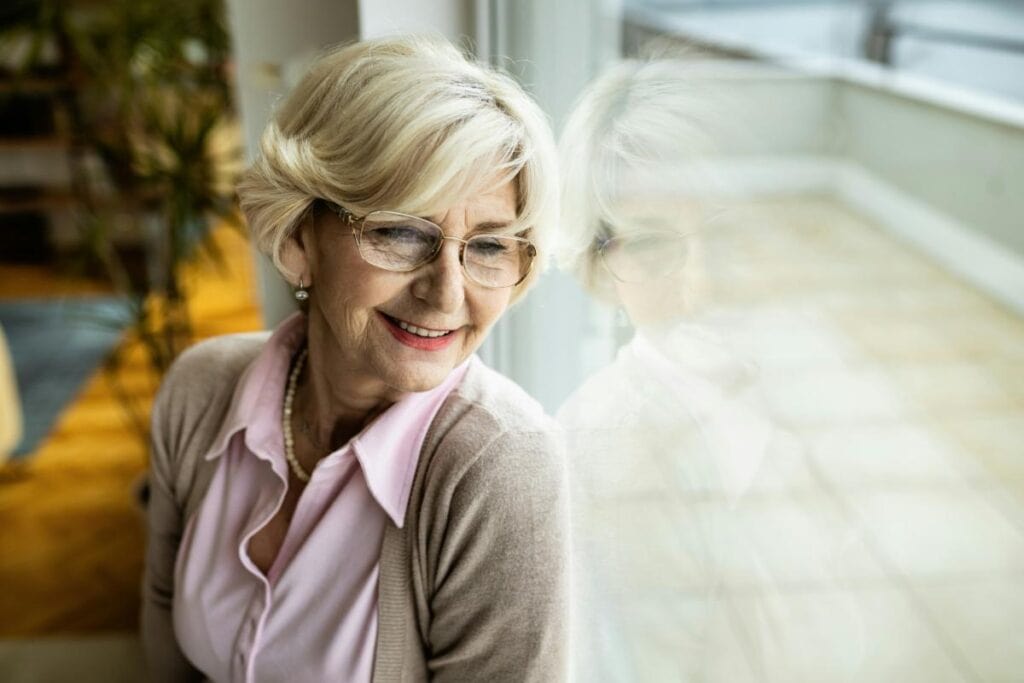 older woman with glasses near a window