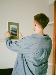 person placing photo on mantle
