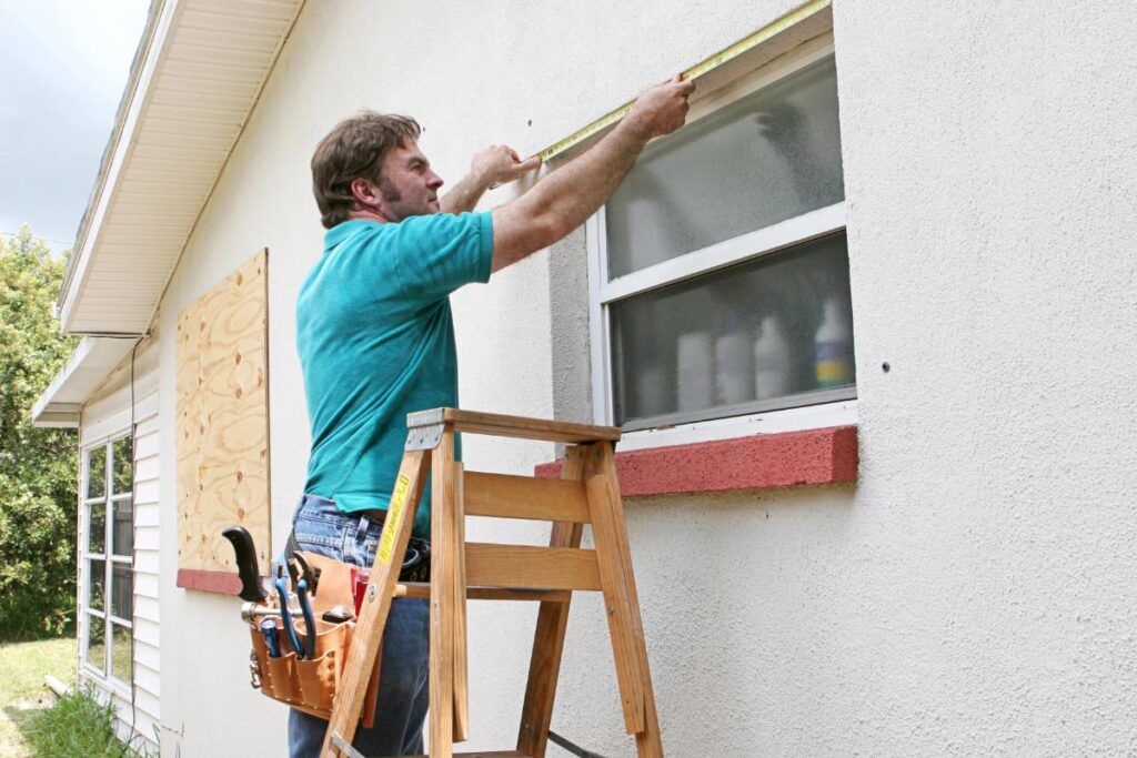 man measuring windows for replacement