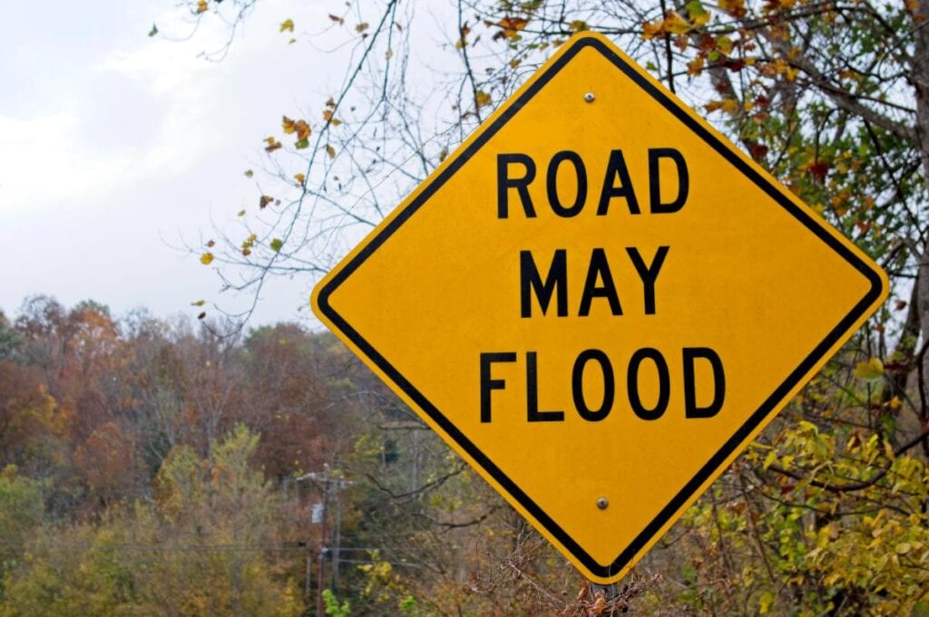 sign that reads road may flood