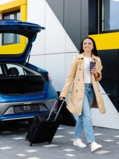 woman getting luggage out of electric rental car