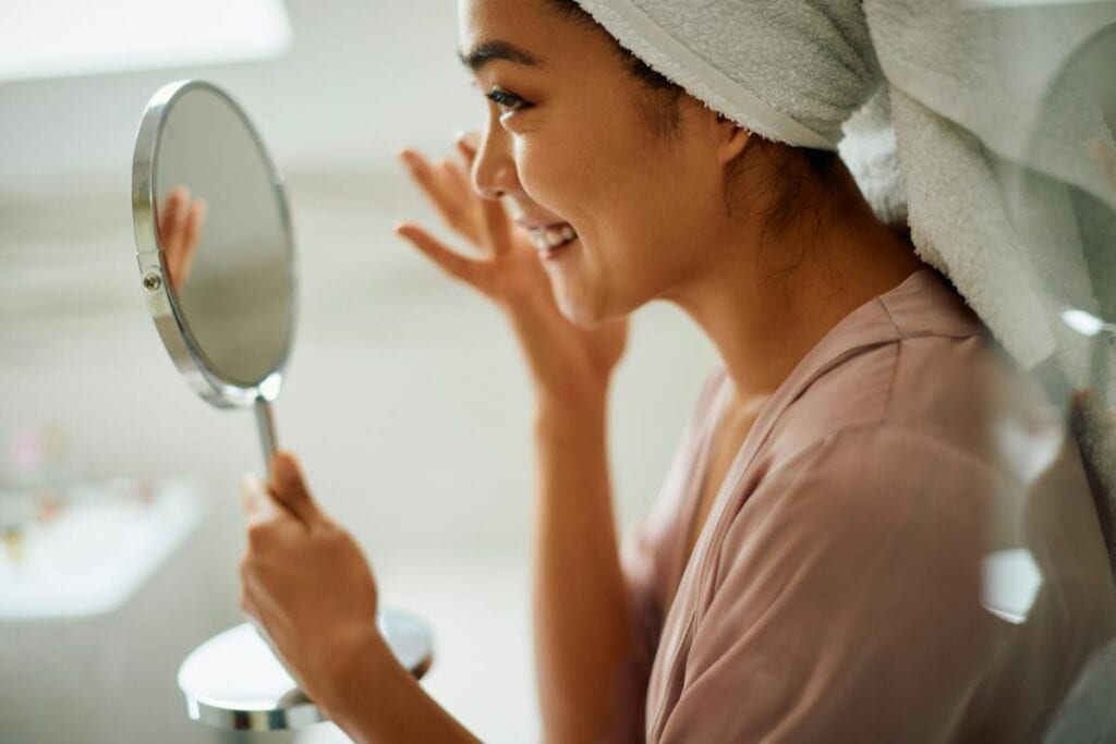 woman looking at herself in the mirror
