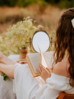 woman with book and mirror in field